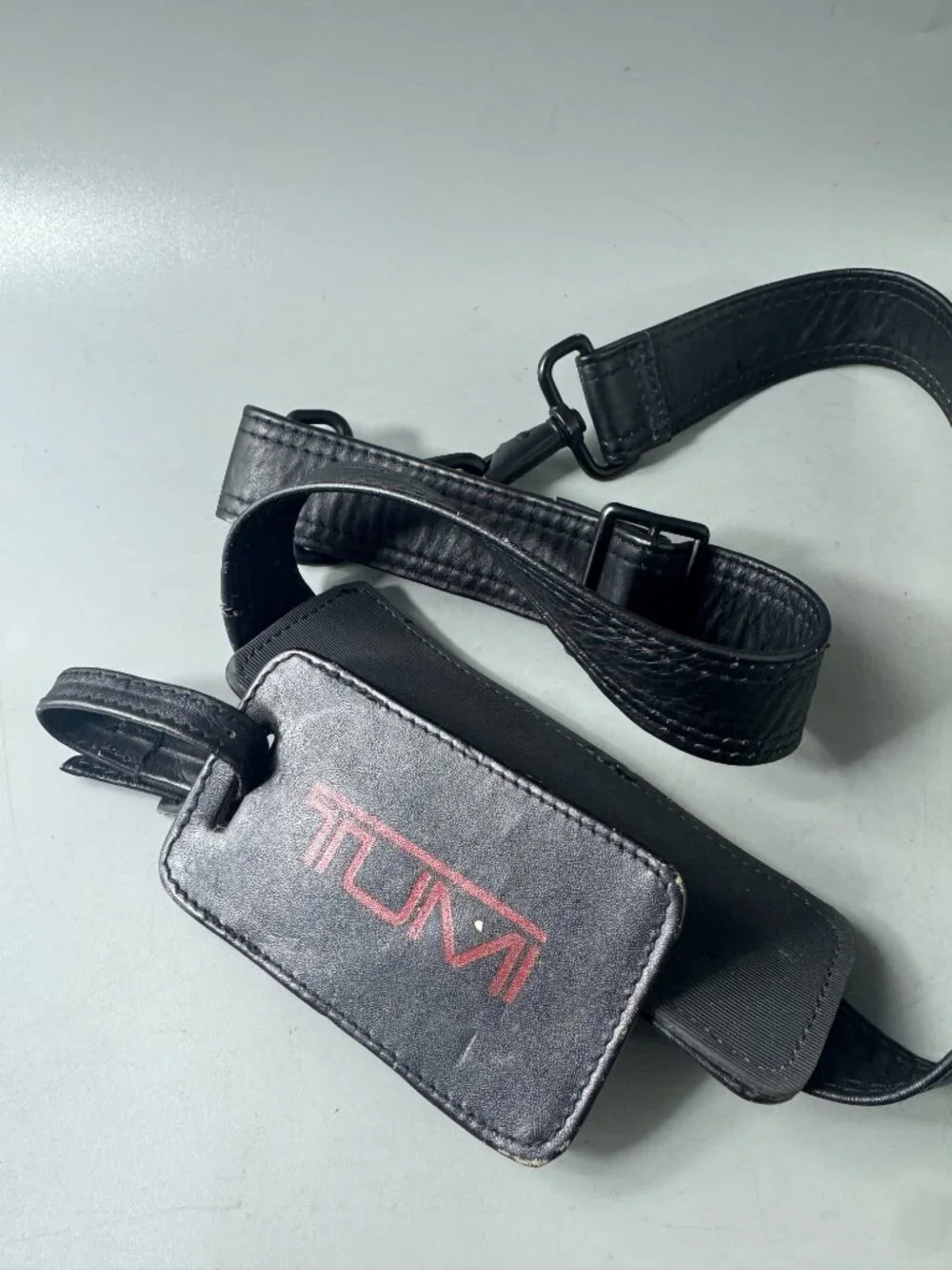 A Bundle of Two (2) Vintage Tumi Black Leather Strap and Travel Tag